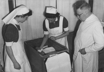 502489 Afbeelding van prof. dr. K. de Snoo (rechts, hoogleraar in de verloskunde) met twee verpleegkundigen (links: ...